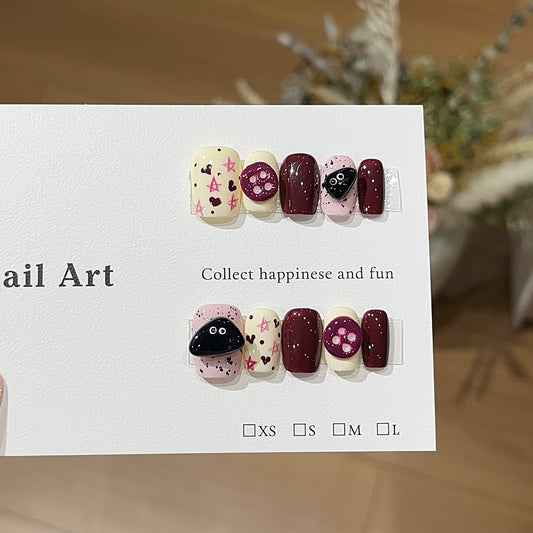Hand-painted burgundy, pink and cream press-on nails with heart and dot nail art design
